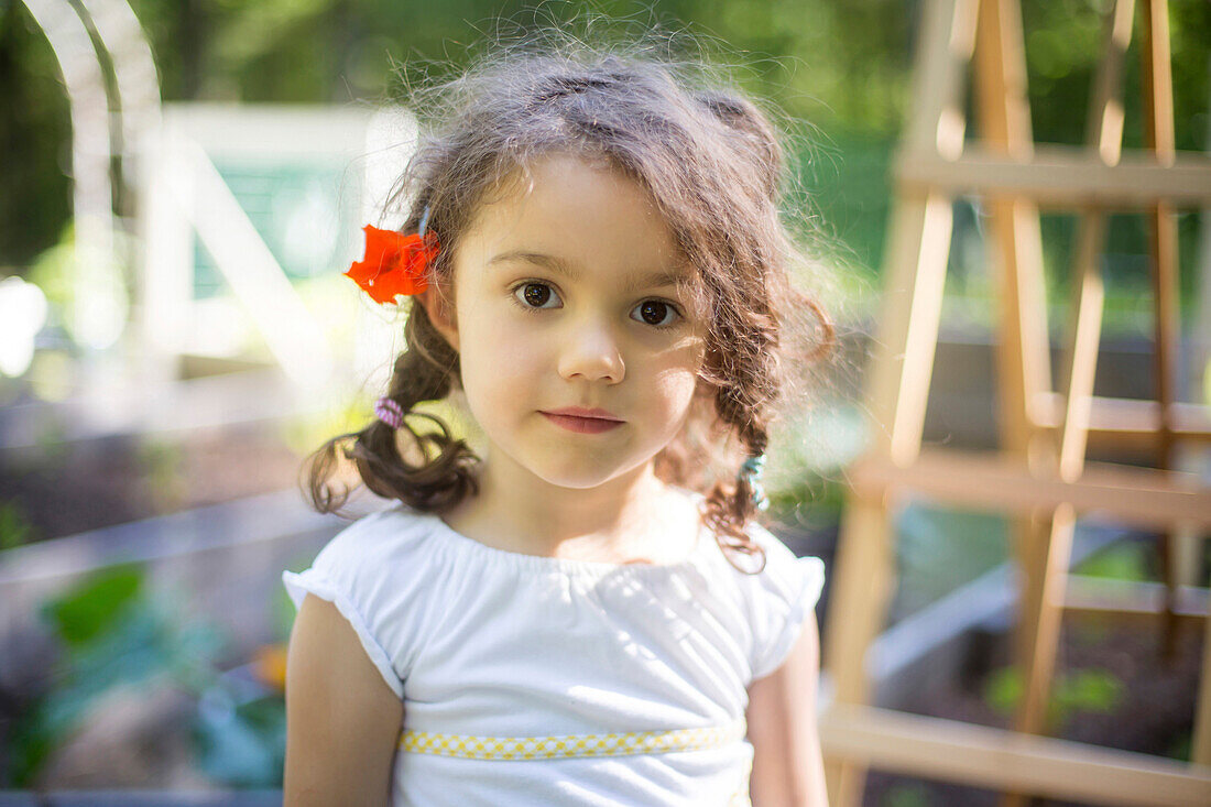 Smiling girl wearing flower in hair in garden