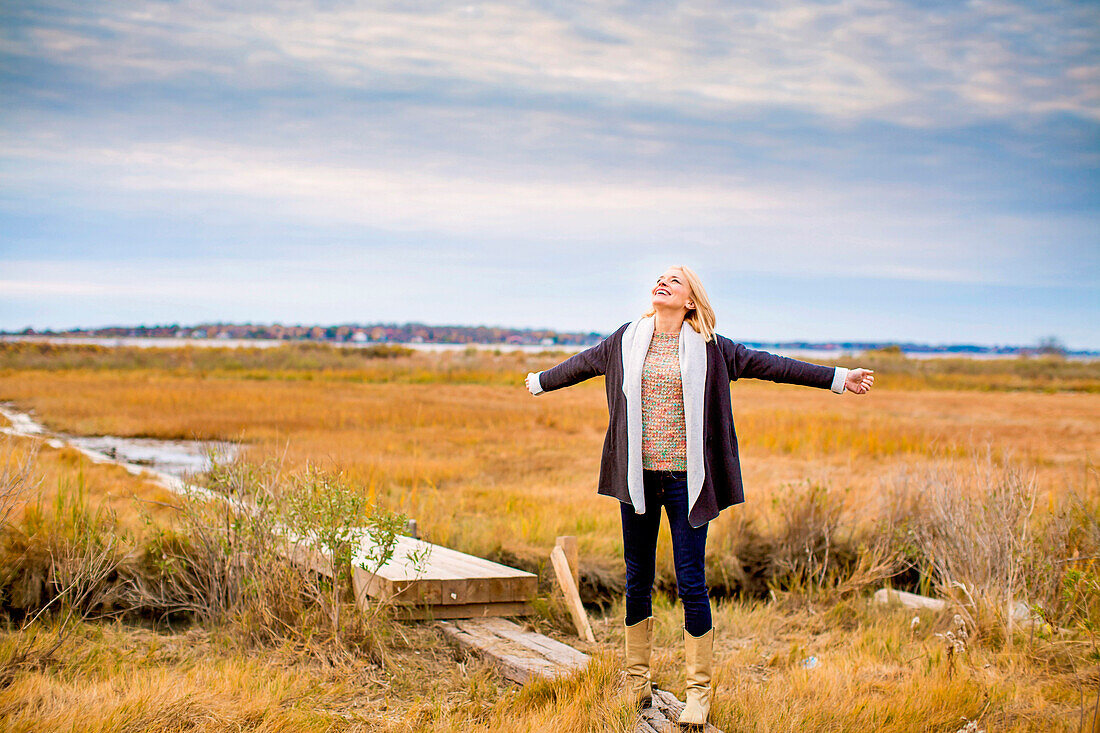 Caucasian woman standing on walkway in rural field