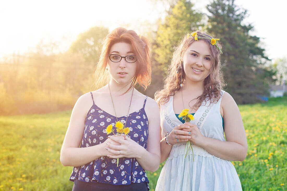 Caucasian women holding flowers in field