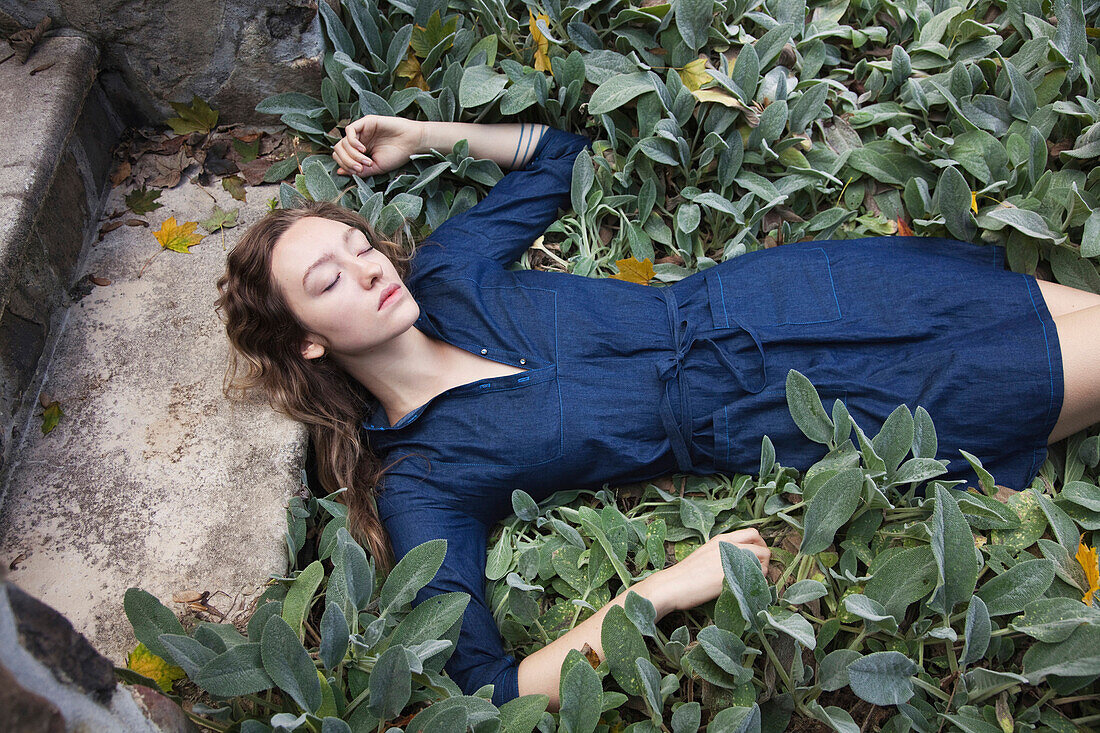 Woman sleeping in leafy garden