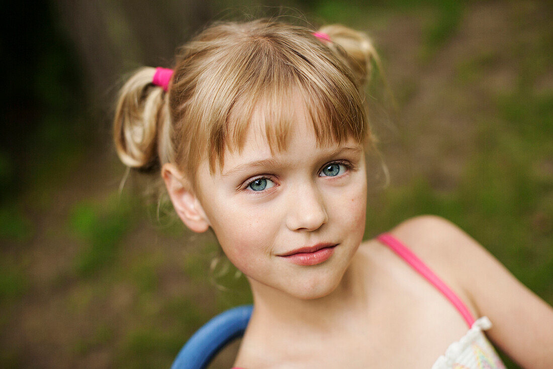 Close up of smiling girl siting in backyard