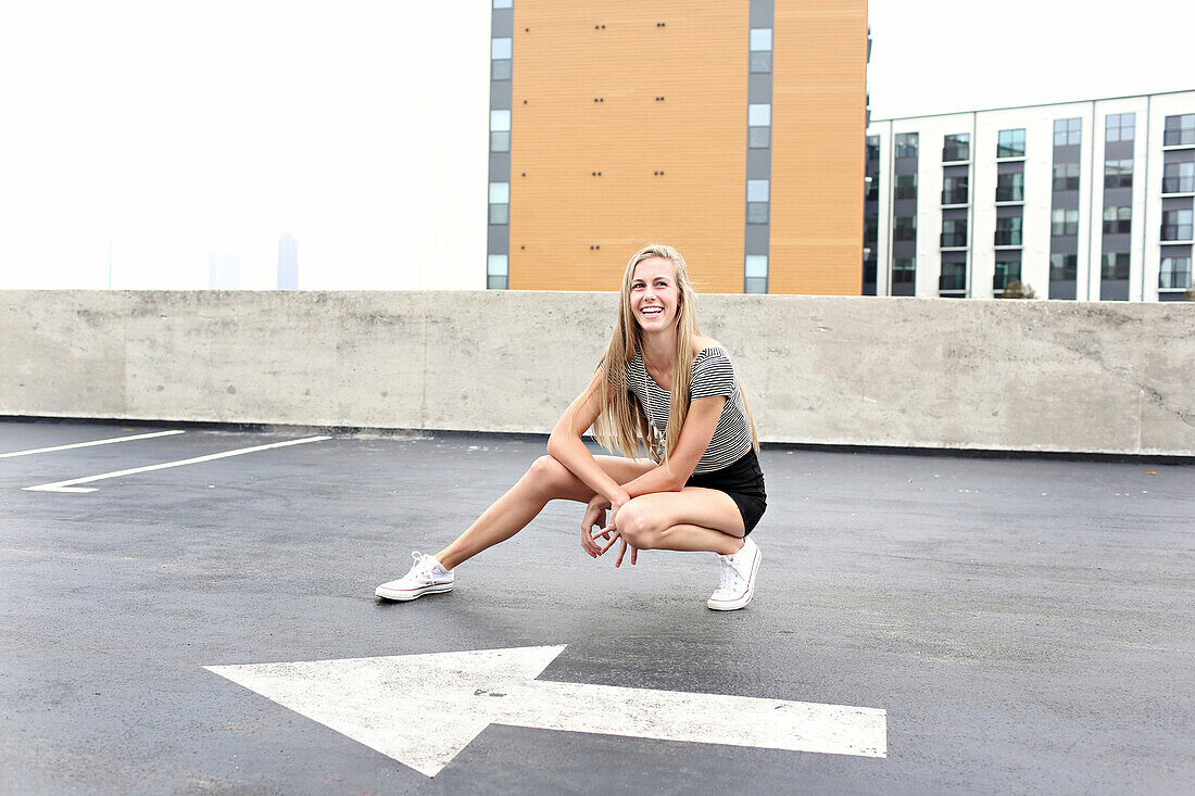 Teenage girl posing on urban rooftop parking lot
