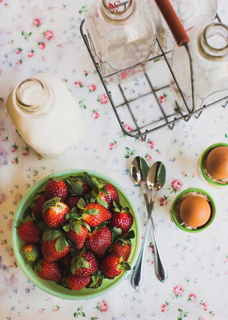 Strawberries, eggs and milk on table