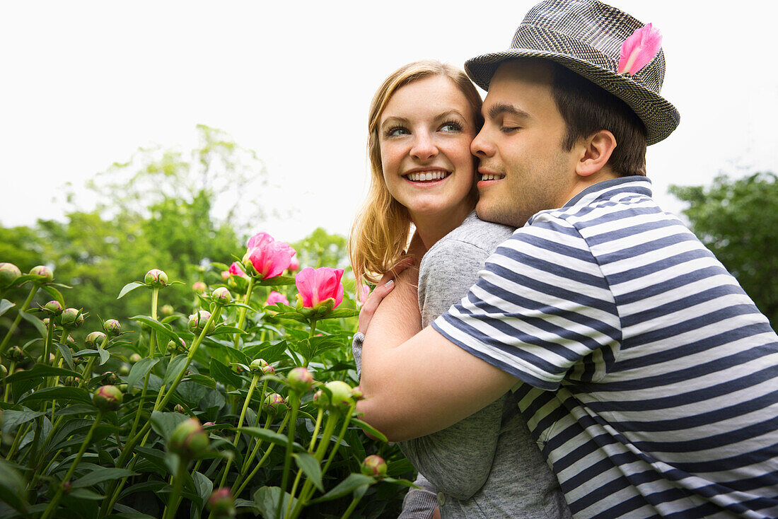 Caucasian man hugging girlfriend in garden