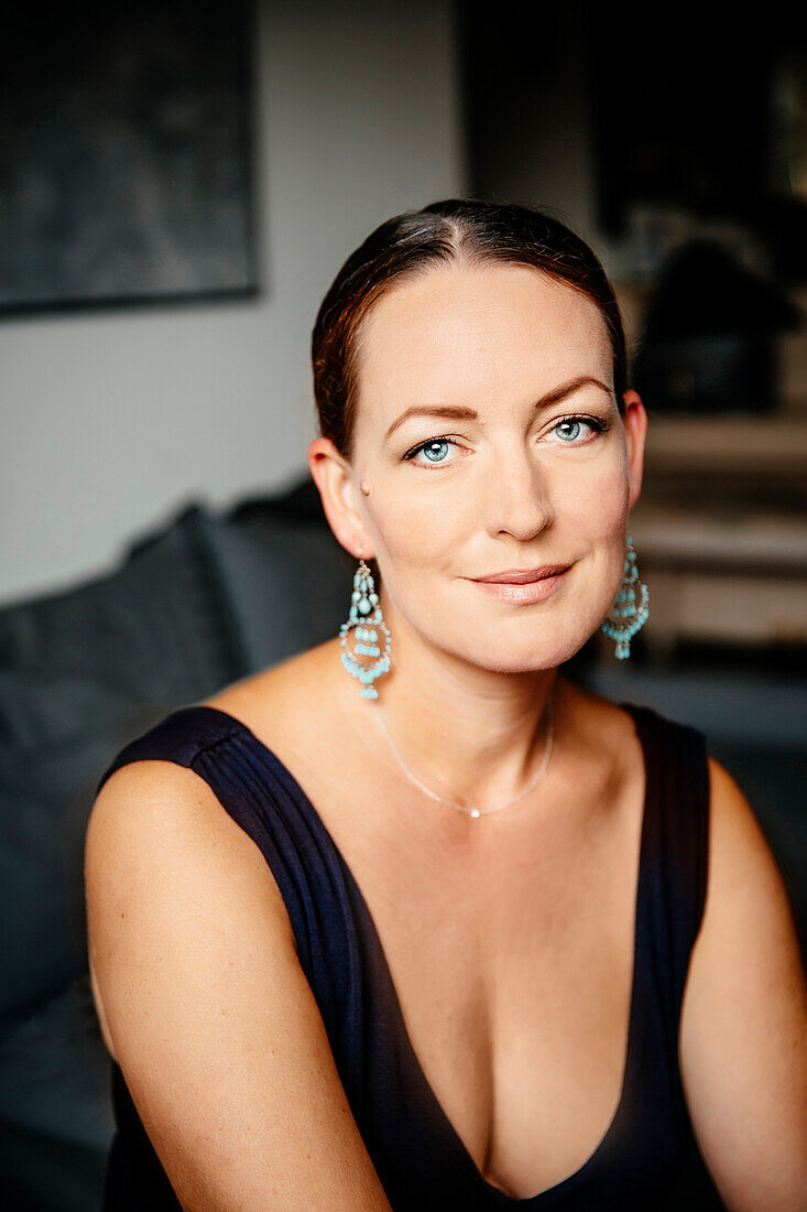 Caucasian woman in evening gown sitting on sofa