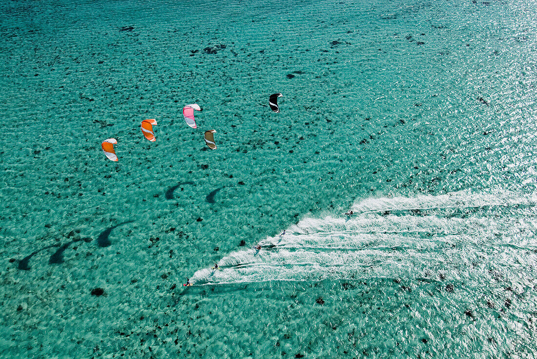 Aerial view of people kitesurfing on ocean