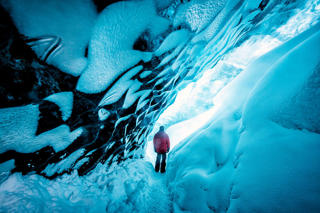 Hiker walking in ice cave