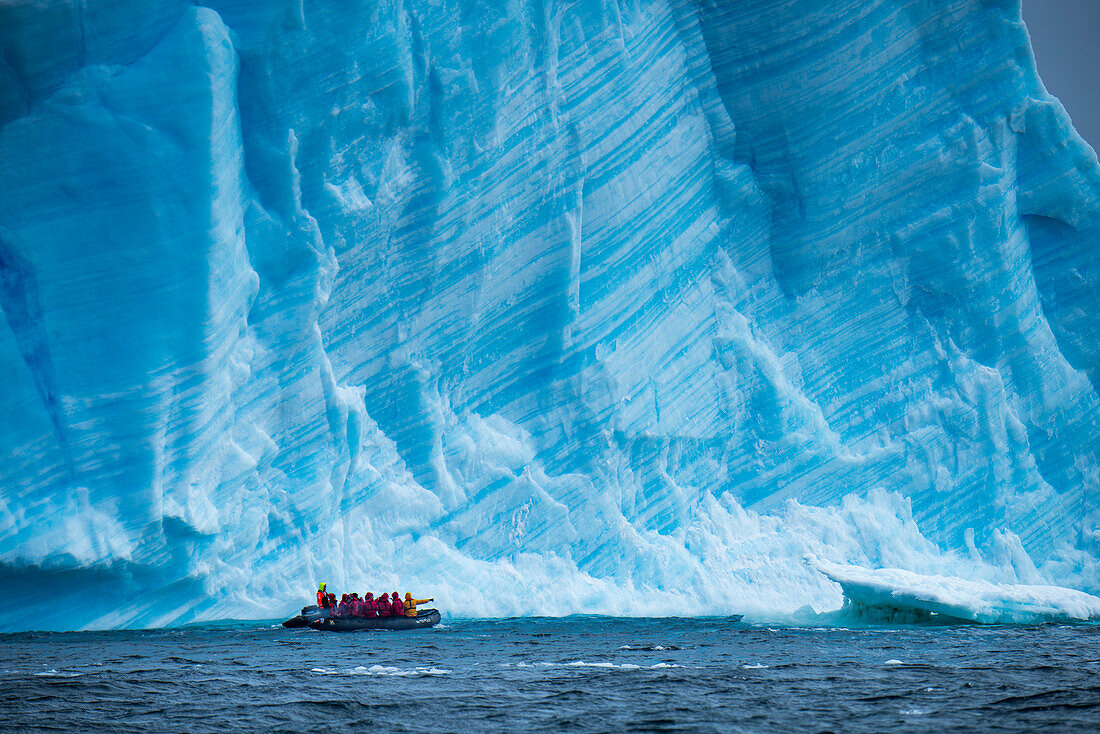 A Zodiac raft from expedition cruise ship MS Hanseatic Hapag-Lloyd Cruises in front of an iceberg, near South Orkney Islands, Antarctica