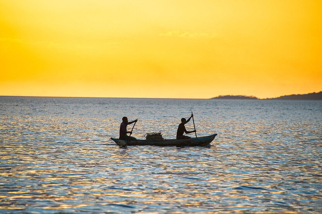 Backlight of fishermen in a little fishing boat at sunset, Lake Malawi, Cape Maclear, Malawi, Africa