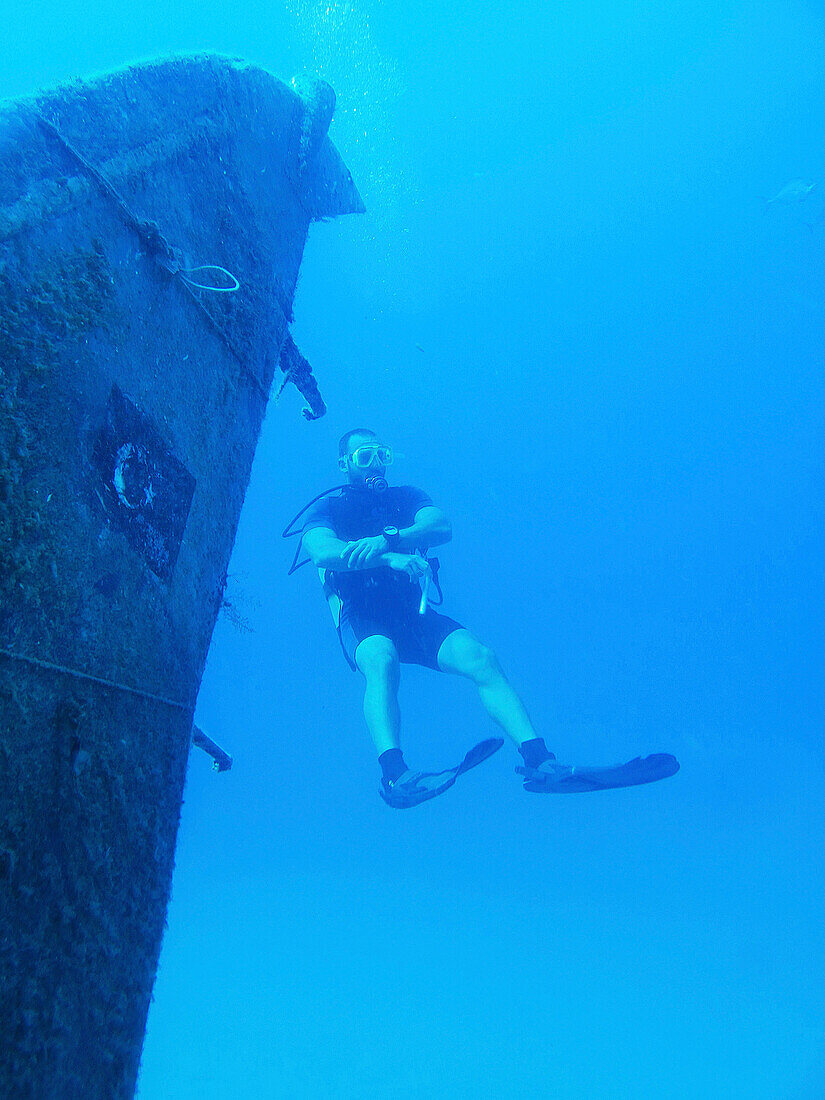 diver staying near plane wreck