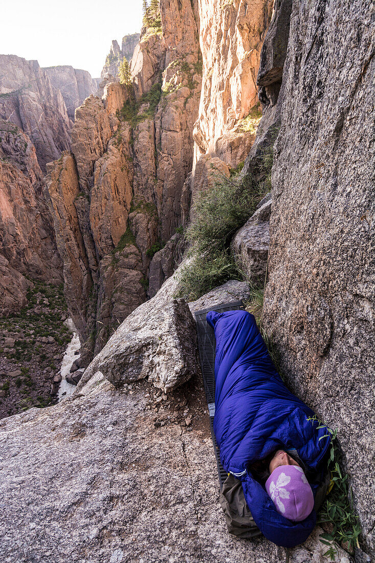 Woman camping on ledge in the Black Canyon of the Gunnison, Montrose, Colorado.