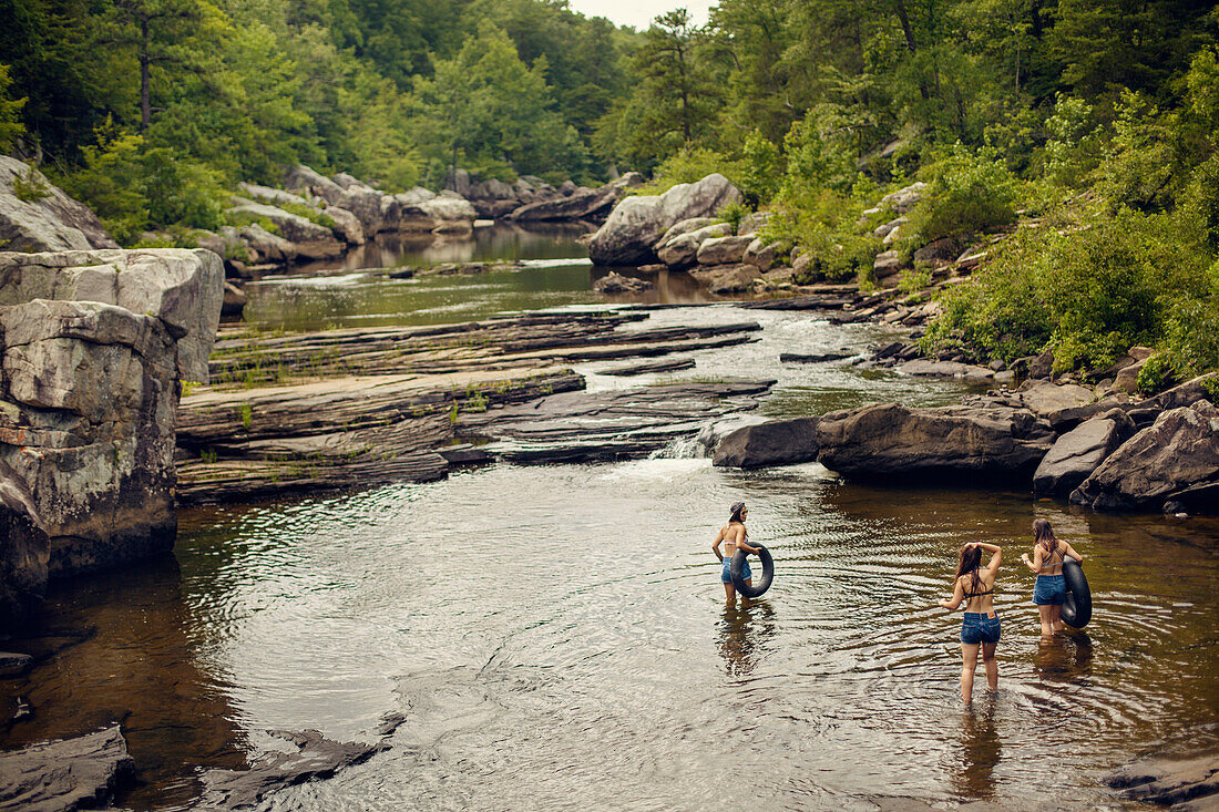 Three young women hike and play in the water at Little River Canyon National Reserve.