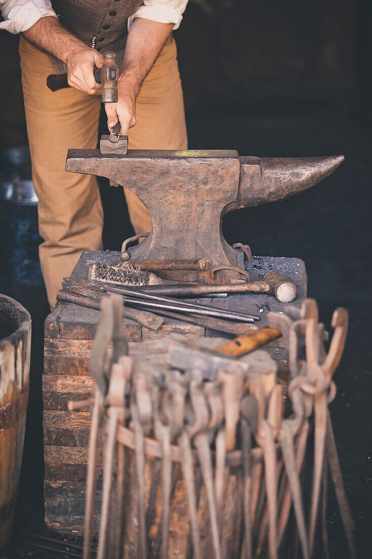 A blacksmith works to forge a metal ring.