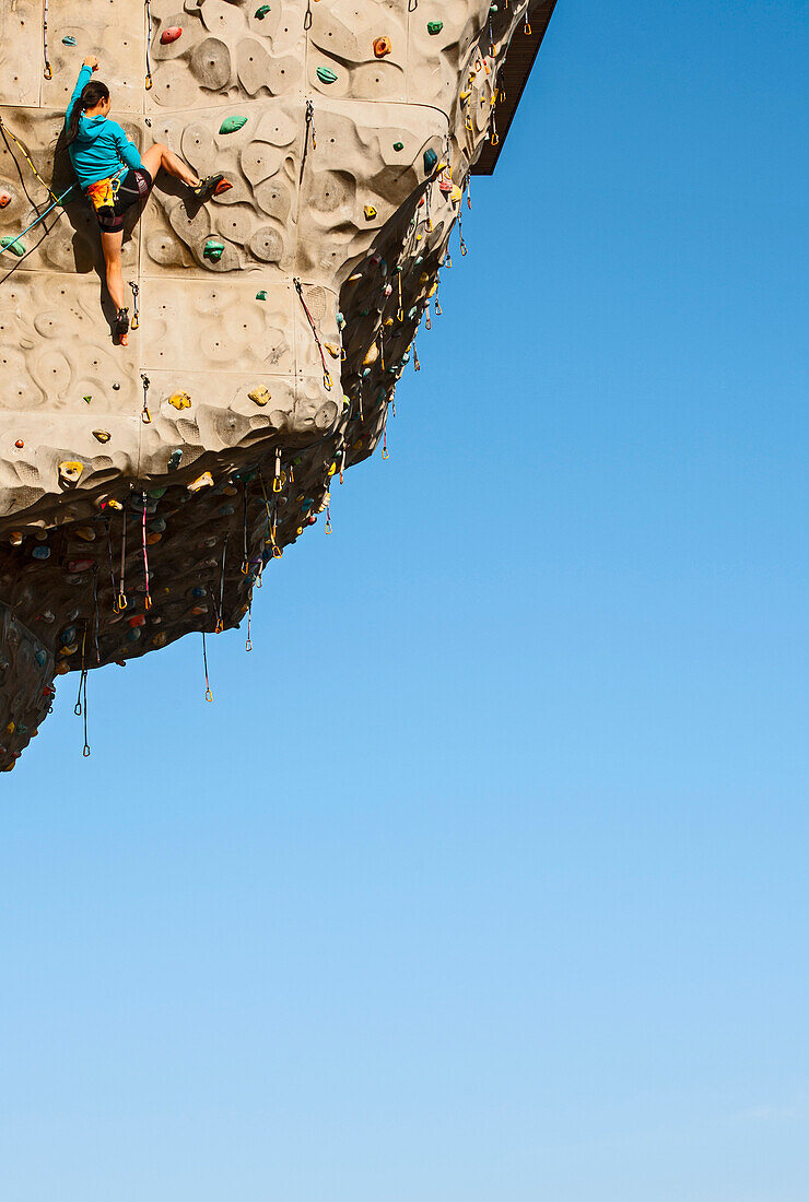 Woman climbing on artificial climbing wall in Seoul