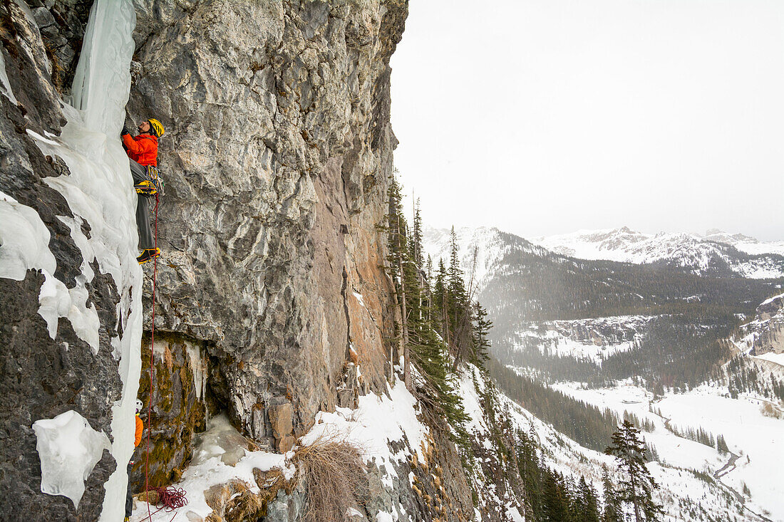 A man and woman ice climbing a frozen waterfall called The Talisman along the Camp Bird Road near Ouray, Colorado.