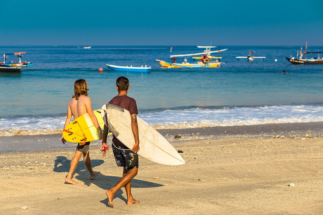 Surfers on a beach, Bali, Indonesia.