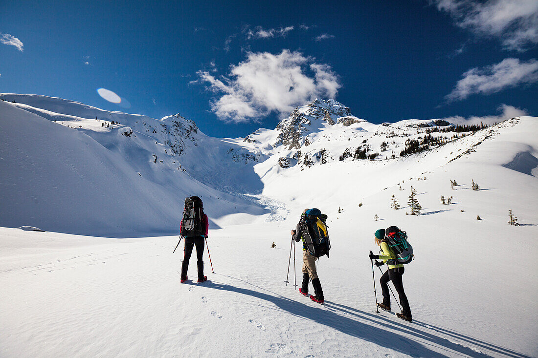 Three climbers head  towards the summit of Joffre Peak, British Columbia, Canada.