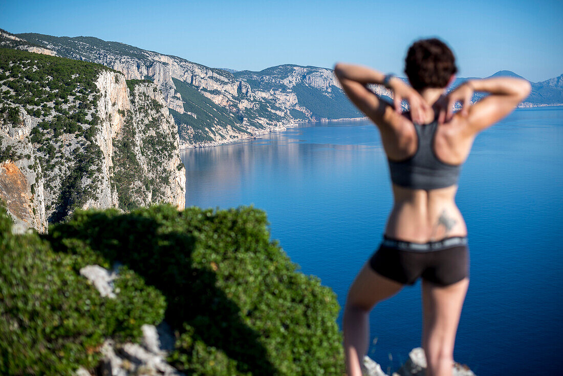 Fit girl stands in front of a great lanscape in Sardinia, Italy, while hiking Selvaggio Blu, a 6 days hike that is supposed to be the hardest trail in Europe because of the lack of water, some climbign and rapelling sections and because is often difficult