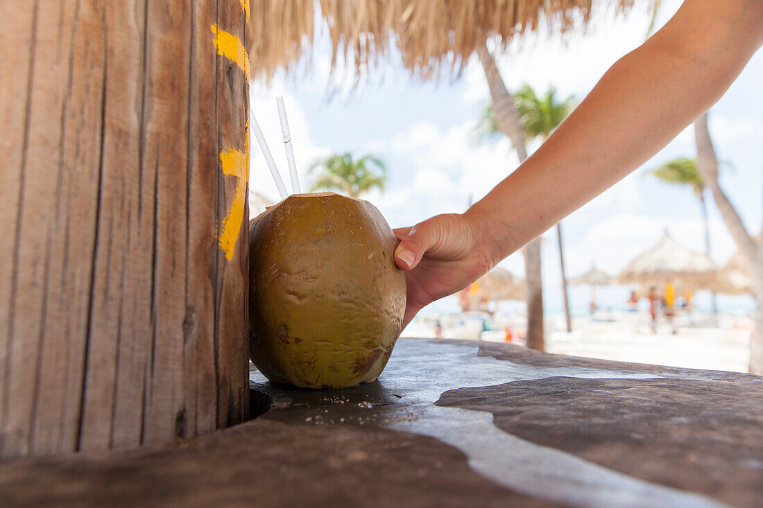 Reaching for a coconut drink at a beach resort.