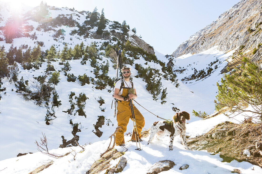 Backcountry skier with his dog in the Ammergauer Alps, Bavaria, Germany