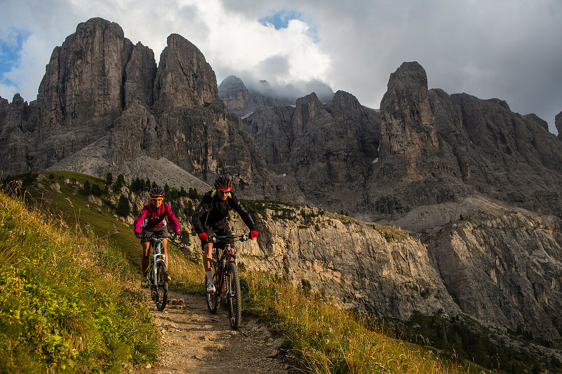 Mountainbiker am Grödner Joch, dahinter Sella Gruppe, Trentino-Südtirol, Italien