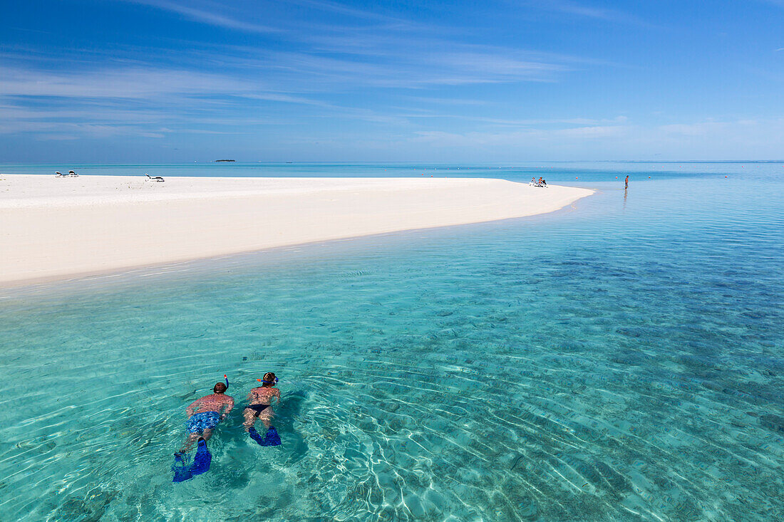 Ein Mann und eine Frau beim Schnorcheln entlang des Strands, Meeru Island Resort, Meerufenfushi, Nord-Male-Atoll, Malediven