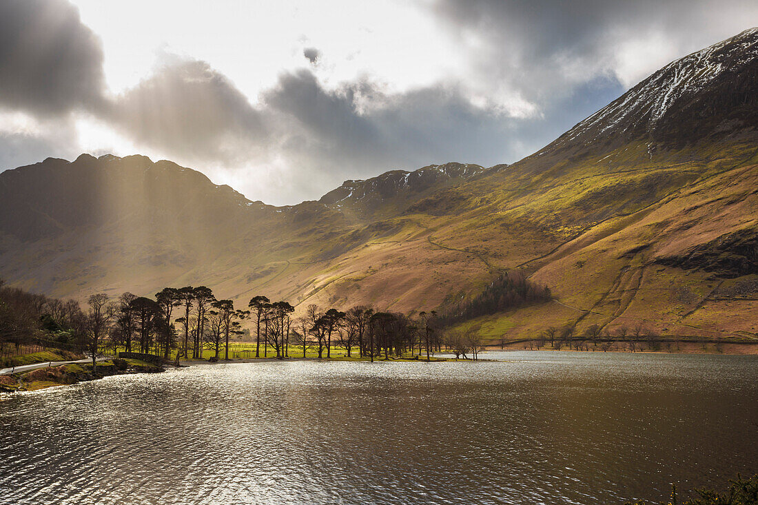 Shafts of light break through clouds to illuminate the fells in winter, Buttermere, Lake District National Park, Cumbria, England, United Kingdom, Europe