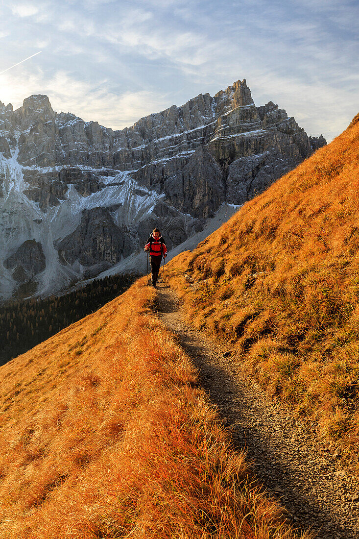 Hiker on a trail around the Forcella De Furcia at sunrise, Val di Funes, South Tyrol, Dolomites, Italy, Europe