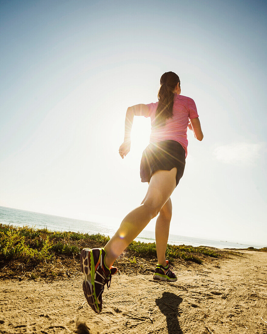 Caucasian woman jogging on dirt path