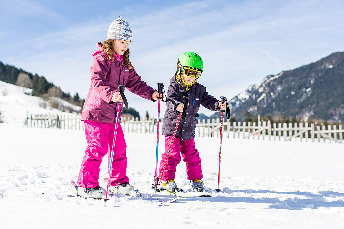 Junge und Mädchen beim Skifahren auf der Piste, Pfronten, Allgäu, Bayern, Deutschland