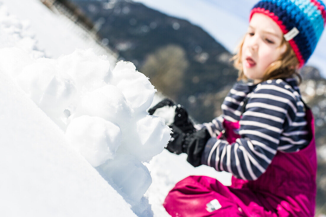 Junge formt Schneebälle im Winter, Pfronten, Allgäu, Bayern, Deutschland