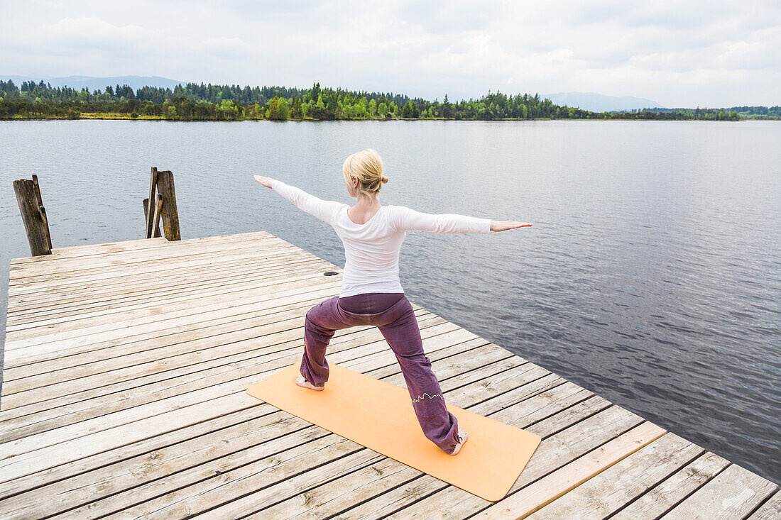 Frau macht Yoga auf dem Steeg, Sonnengruß, Kirchsee, Bad Tölz, Bayern, Deutschland