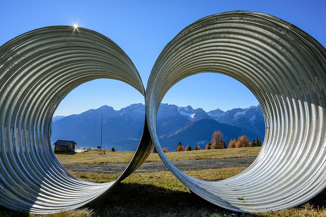 View through two big pipes towards mountain range, Schober Range, High Tauern, East Tyrol, Tyrol, Austria