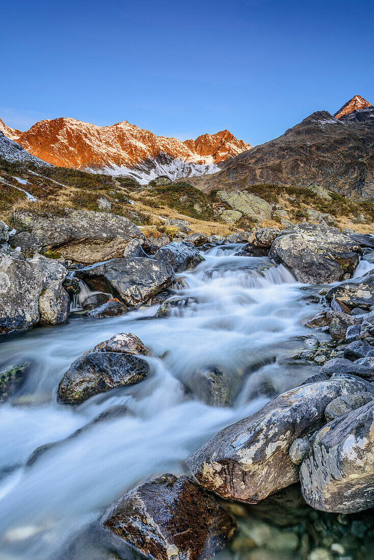 Mountain river with Debantgrat and Ralfkopf in alpenglow in background, valley of Debanttal, Schober Range, High Tauern, High Tauern National Park, East Tyrol, Tyrol, Austria