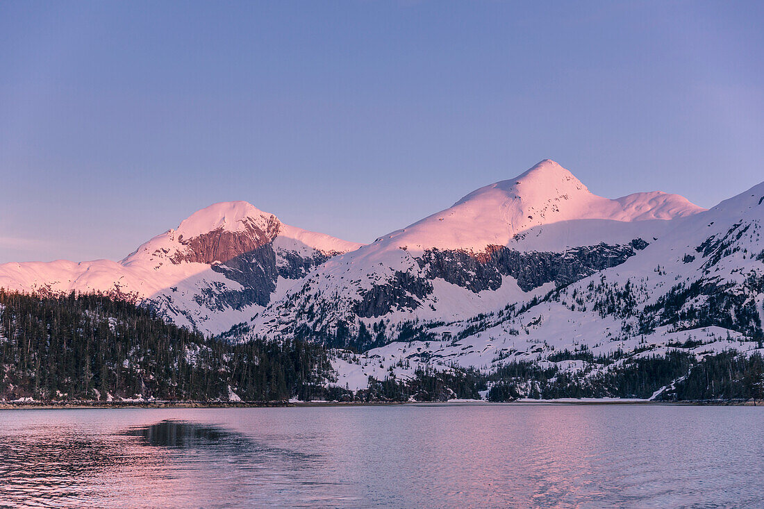 Golden hour light on snow covered peaks in Kings Bay in winter, Prince William Sound, Alaska, United States of America