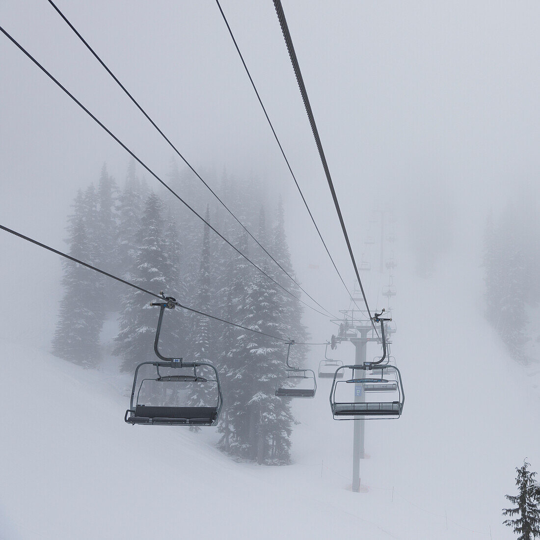 Empty chairlift at a ski resort in fog, Whistler, British Columbia, Canada