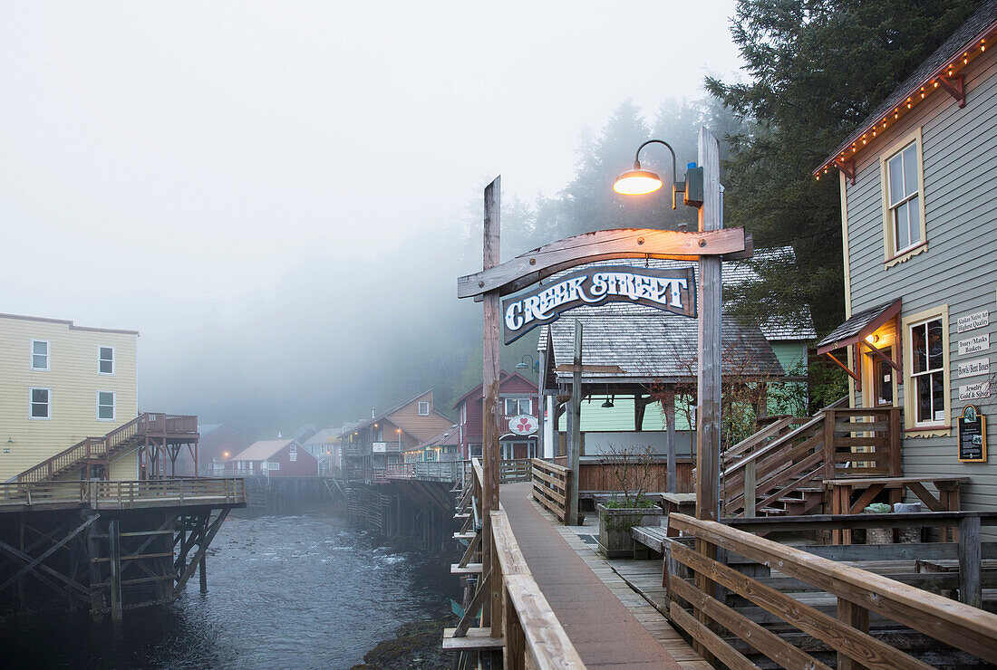 The Creek Street sign and boardwalk in the fog, downtown Ketchikan, Southeast Alaska, USA, Spring