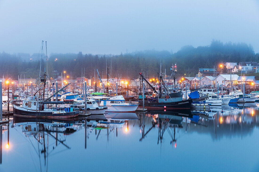 Boats in Ketchikan Harbor reflecting on the calm ocean waters on a foggy night, Ketchikan, Southeast Alaska