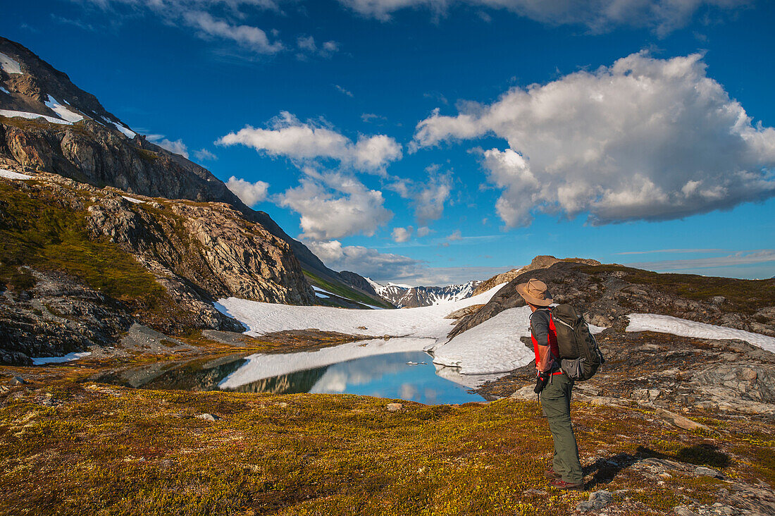 Man hiking alongside a lake while hiking the Harding Icefield Trail, Kenai Fjords National Park, Kenai Peninsula, Southcentral Alaska