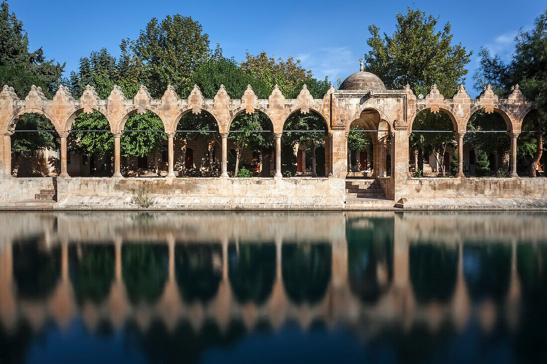 Chamber of Abraham, wall reflected in the tranquil water of a lake, Sanliurfa, Turkey