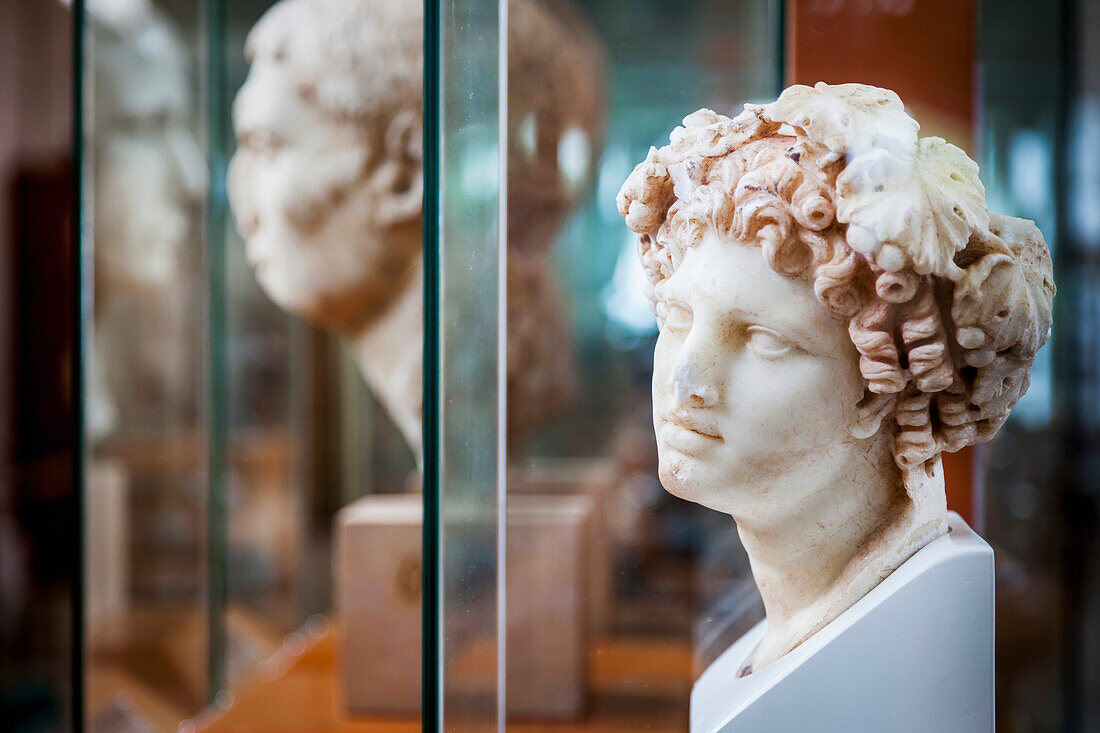 Sculpture of female head with curly hair at an archaeological museum, Corinth, Greece