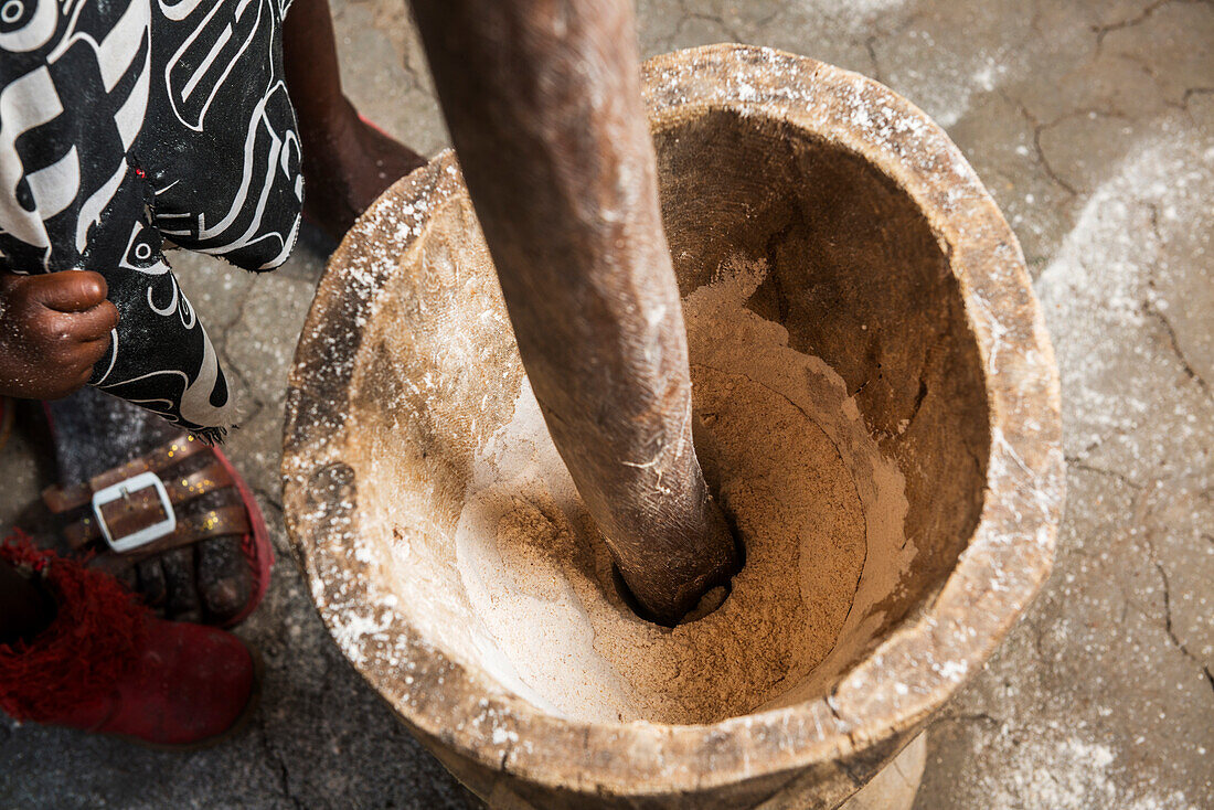 Pounding sorghum with a mortar and pestle in Sexaxa Village, Maun, Botswana