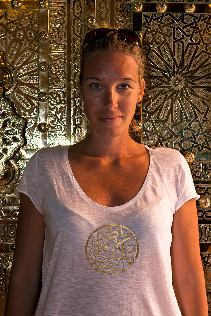 Woman against an ornamented brass door, Marrakech, Morocco