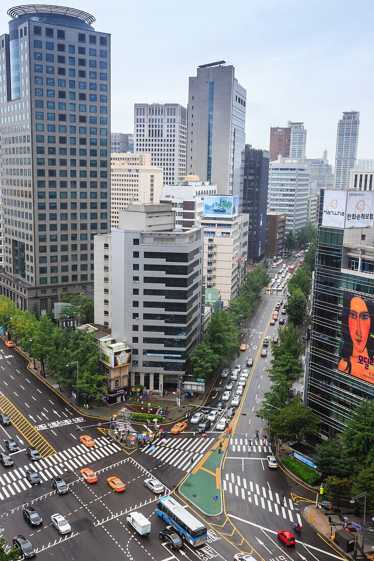 Elevated view of a busy city centre street and high rise buildings on a rainy summer day, City Hall area, Seoul, South Korea, Asia