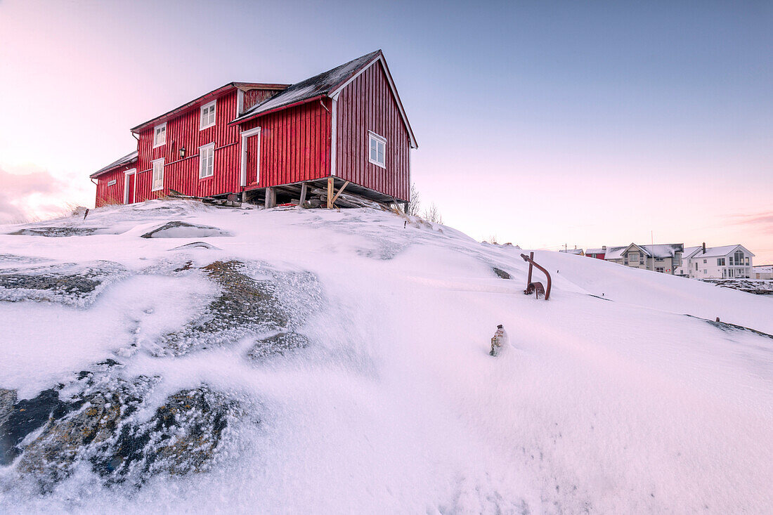 Pink sky on the typical red house of fishermen rorbu, Henningsvaer, Lofoten Islands, Arctic, Northern Norway, Scandinavia, Europe