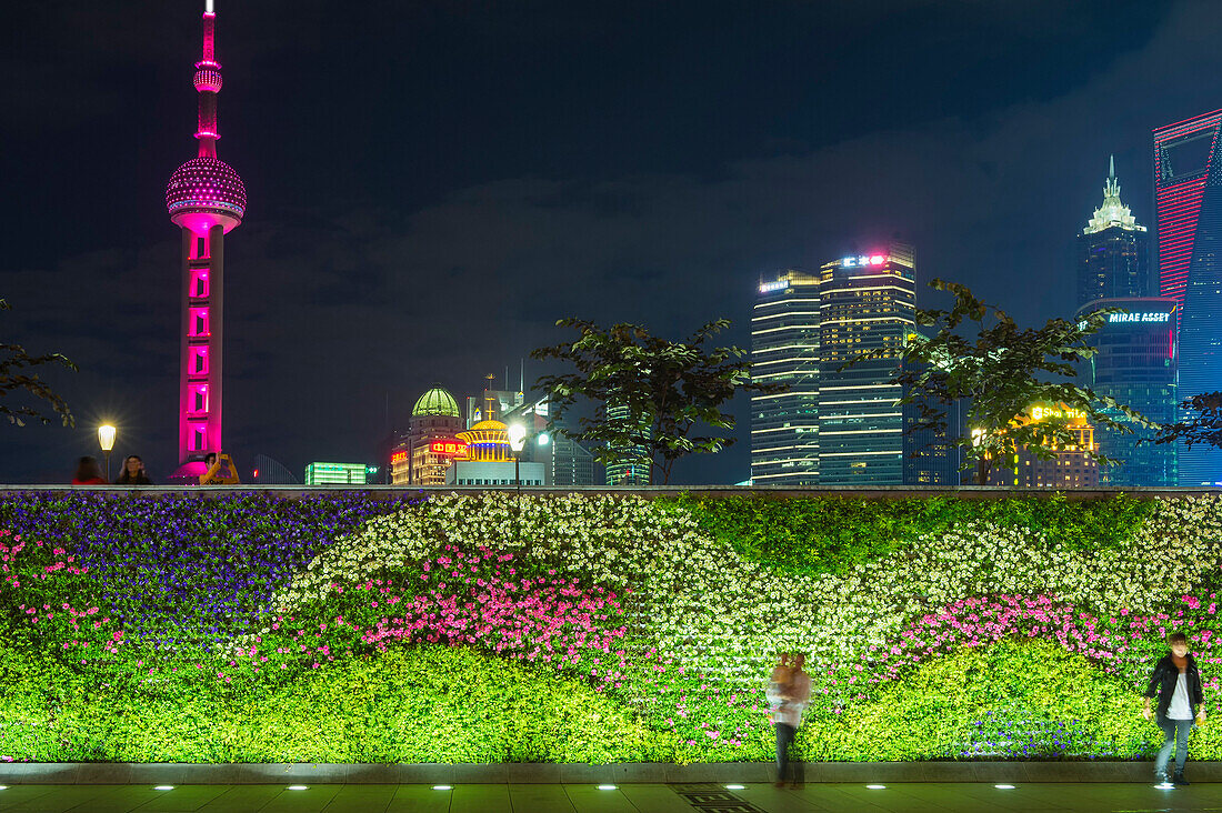 Vegetal wall on the Bund and view over Pudong financial district skyline at night, Shanghai, China, Asia