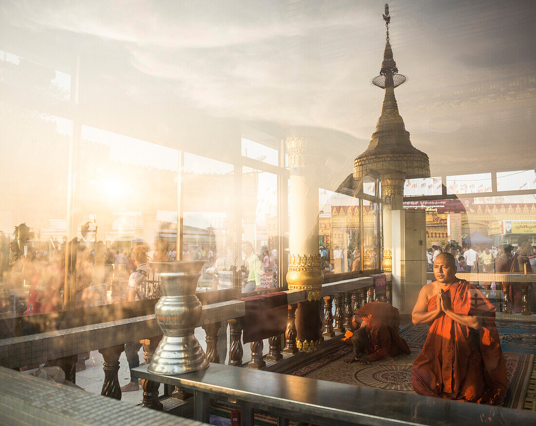 Buddhist Monks praying at Golden Rock Temple Kyaiktiyo Pagoda at sunset, Mon State, Myanmar Burma, Asia