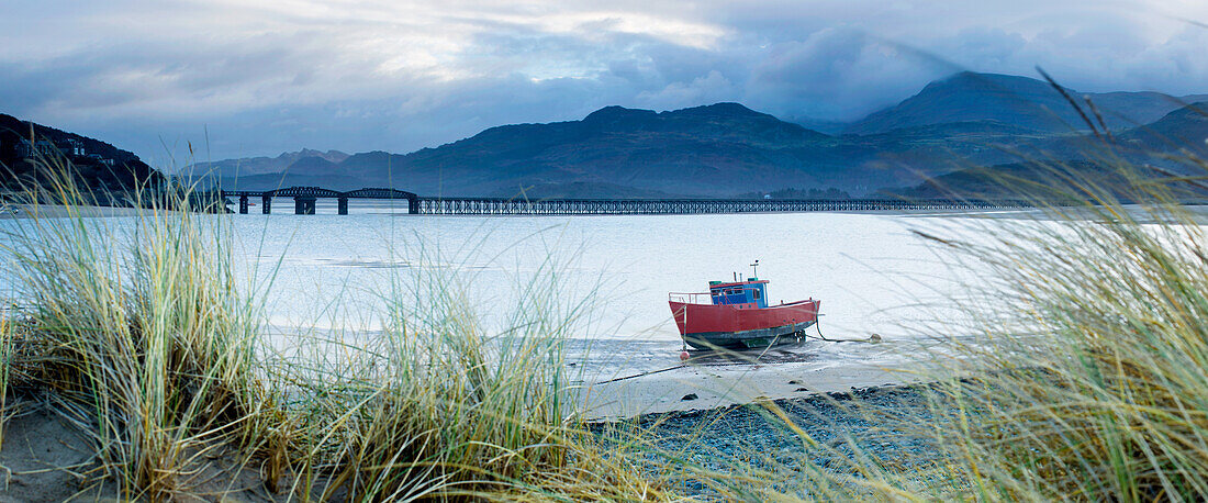 Fishing boat with Barmouth Bridge in background, coast of Cardigan Bay, Gwynedd, Wales, United Kingdom, Europe