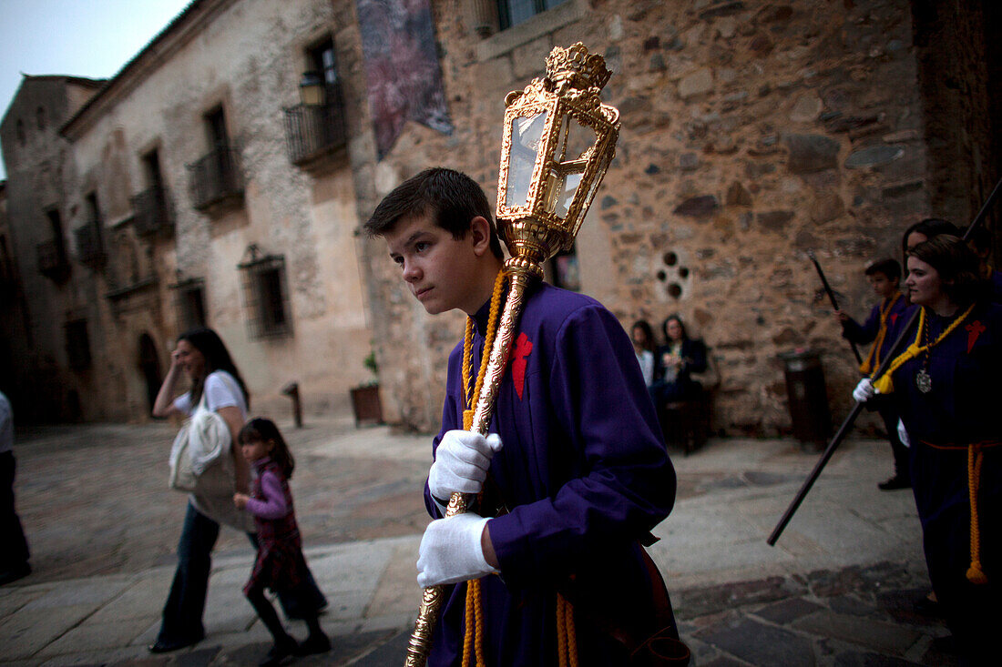 An altar boy holds a lump during Easter Holy Week in Caceres, Extremadura, Spain