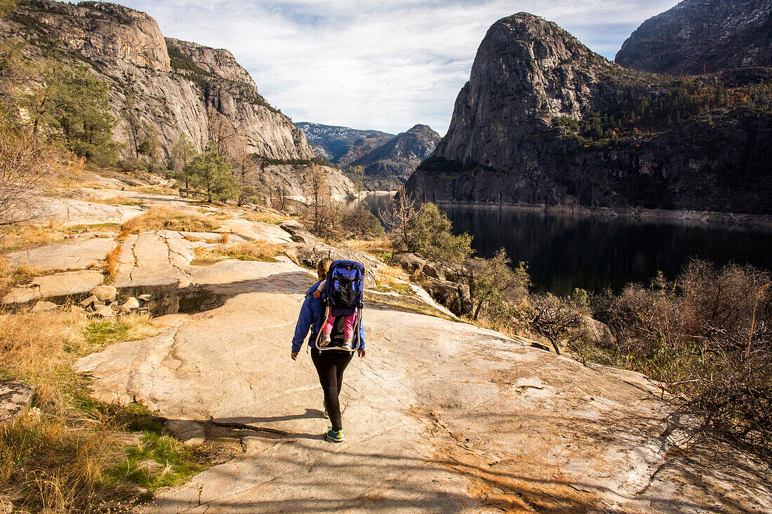 Caucasian mother carrying daughter in Yosemite National Park, California, United States